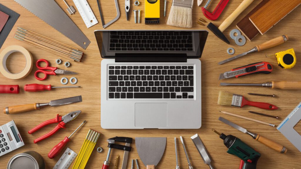 Laptop omringd door gereedschap als symbool voor professioneel website onderhoud, updates, beveiliging en technisch beheer.